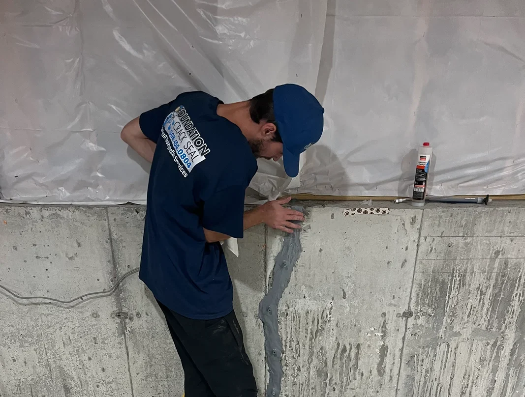 Garrett Budlong of Foundation Crack Seal repairing a foundation wall crack